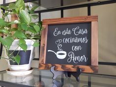 a sign that is on top of a glass shelf next to a potted plant