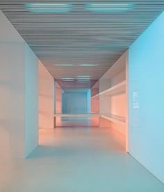 an empty room with white walls and flooring is lit by light from the ceiling