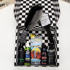 a black and white checkerboard box with various items in it, including a brush