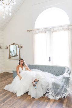 a woman in a wedding dress sitting on a couch