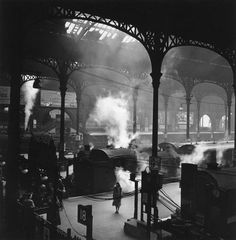 an old black and white photo of steam coming out of the furnaces in a train station