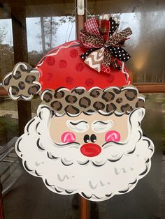 a christmas decoration with a santa claus face and leopard print on the front, hanging from a pole