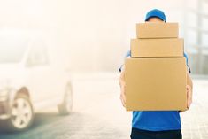 a man carrying a cardboard box on his back