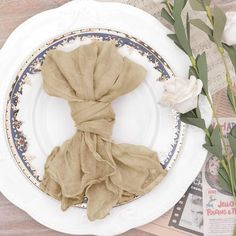 a white plate topped with a napkin and flowers