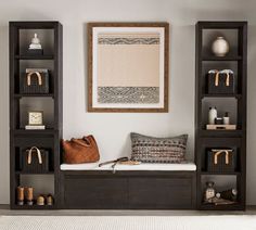 a living room filled with lots of bookshelves next to a white rug on top of a hard wood floor