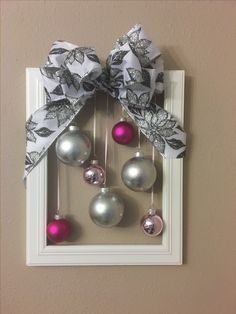 a christmas ornament hanging on the side of a wall next to a bow