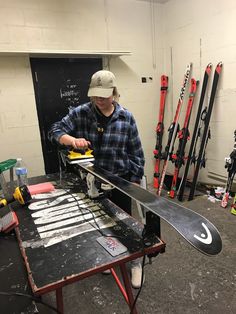 a man is working on some skis in a shop