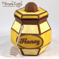 a honey jar with a wooden spoon in it and the word honey written on it