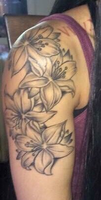 a woman's arm with flowers on it, and the back of her shoulder