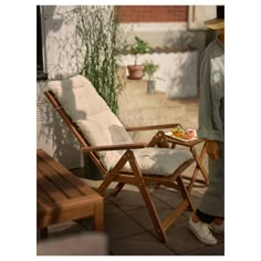 a wooden chair sitting on top of a patio next to a table with food on it