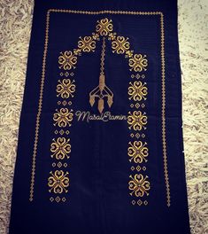 a black scarf with gold embroidered designs on it