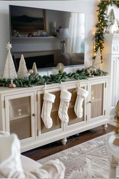 a living room with christmas stockings hanging on the sideboard and fireplace in the background