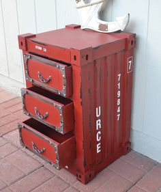 three red drawers are stacked on top of each other in front of a white wall