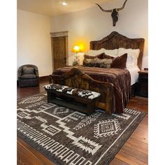 a large bed sitting on top of a wooden floor next to a chair and lamp