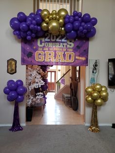 purple and gold balloons are on display at the entrance to an apartment for graduate grad