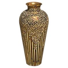 a gold vase with an intricate design on it's body and bottom, sitting against a white background