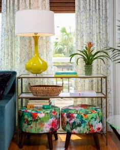 a living room filled with furniture and a yellow lamp on top of a wooden table