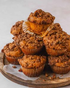 a pile of muffins sitting on top of a wooden plate