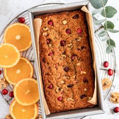 a loaf of bread sitting on top of a table next to oranges and nuts