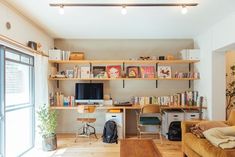 a living room filled with furniture and a flat screen tv mounted above a wooden shelf