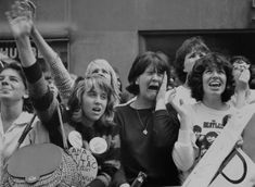 black and white photograph of women protesting in front of a building with their hands up