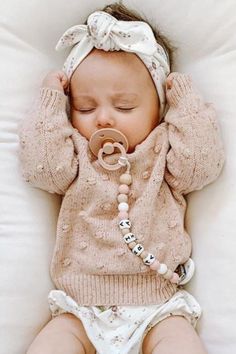 a baby is laying down on a pillow with a pacifier in it's mouth