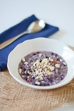 a white bowl filled with oatmeal next to a spoon