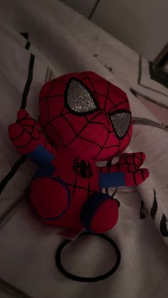 a spider - man stuffed animal is on the bed with its headband up and eyes closed