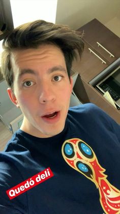 a young man making a funny face while wearing a t - shirt with the world cup on it