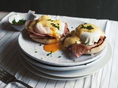 two plates with food on them sitting on a table next to a fork and knife