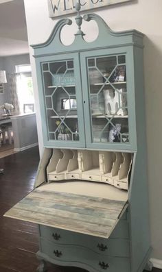 a blue china cabinet sitting on top of a hard wood floor