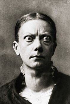 an old black and white photo of a woman with eyes wide open