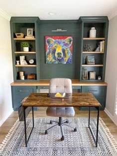 a home office with built - in shelving, desk and artwork on the wall