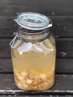 a jar filled with liquid sitting on top of a wooden table