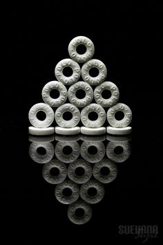 a stack of white doughnuts sitting on top of a black table next to a mirror