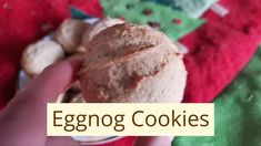 an eggnog cookie is being held up by someone's hand with the words eggnog cookies in front of them