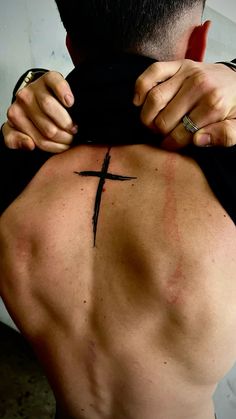 a man with a cross tattoo on his back