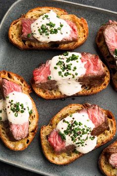 several pieces of bread topped with meat and sour cream