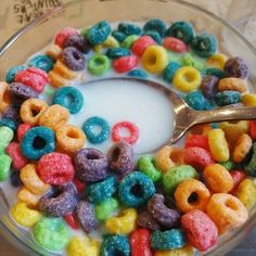 a bowl full of cereal with a spoon sticking out of the top and milk in it