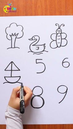 a person is writing numbers on a piece of paper with a marker and some pencils