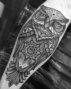 an owl tattoo on the arm