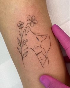 a woman's arm with a tattoo on it and flowers in the corner next to her