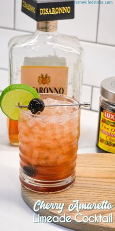 a close up of a drink in a glass with a lime slice on the rim