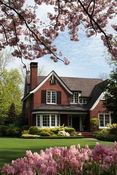 a red brick house surrounded by pink flowers