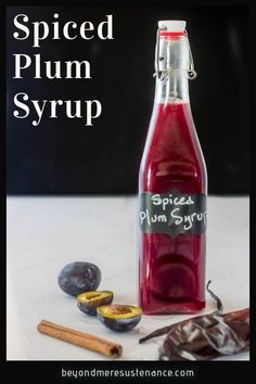 a bottle of spiced plum syrup next to some fruit