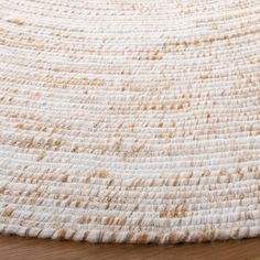 a close up view of a rug on a wooden floor with white and brown colors