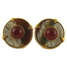 BALENCIAGA vintage gold toned disc clip-on earrings featuring a resin faux wood inlaid and a ruby red glass cabochon at the center. Embossed BALENCIAGA Paris Made in France. Indicative measurements : diameter approx. 3 cm (1.18 inches). NOTES - This is a preloved vintage item, therefore it might have imperfections. - Colors may differ slightly from actual product appearance due to differences in lighting conditions. - As a buyer, you are fully responsible for customs duties, other local taxes and any administrative procedures related to imports into the country of destination. Balenciaga Jewelry, Faux Wood, Red Glass, Ruby Red, Vintage Gold, Made In France, Clip On Earrings, Balenciaga, Cufflinks