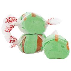 two green and white candy wrapped in plastic wrappers on top of eachother