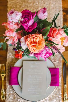 the table is set with pink and orange flowers