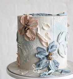 a white and blue cake with flowers on it